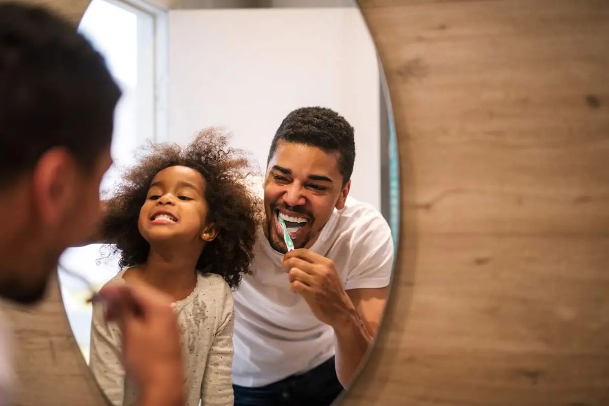 father and son brushing their teeth together