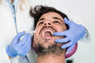 man being fitted for Invisalign clear aligners
