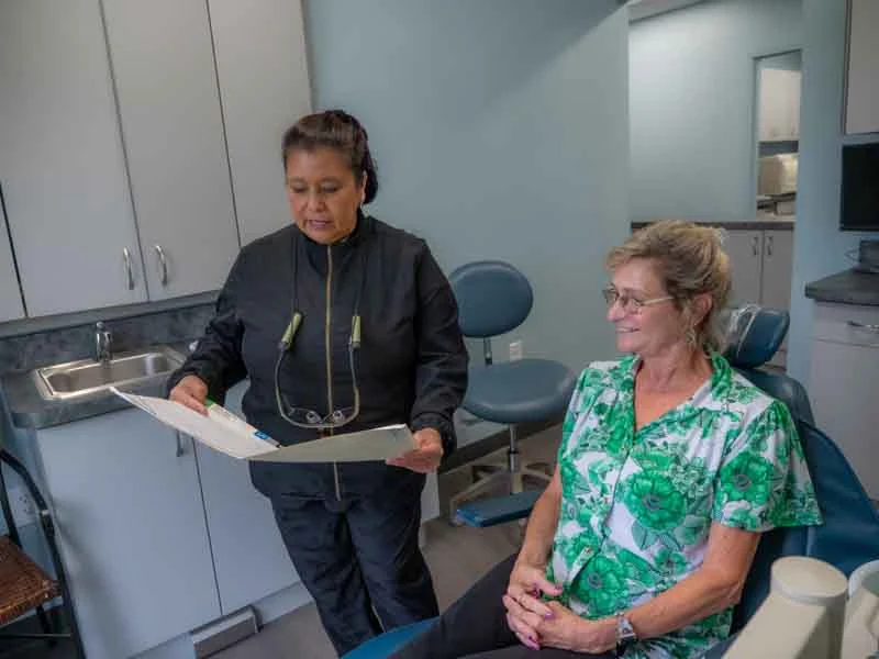 A patient talking with a staff member discussing removabel denture options at Ronald Fuhrmann - Virginia Beach VA.