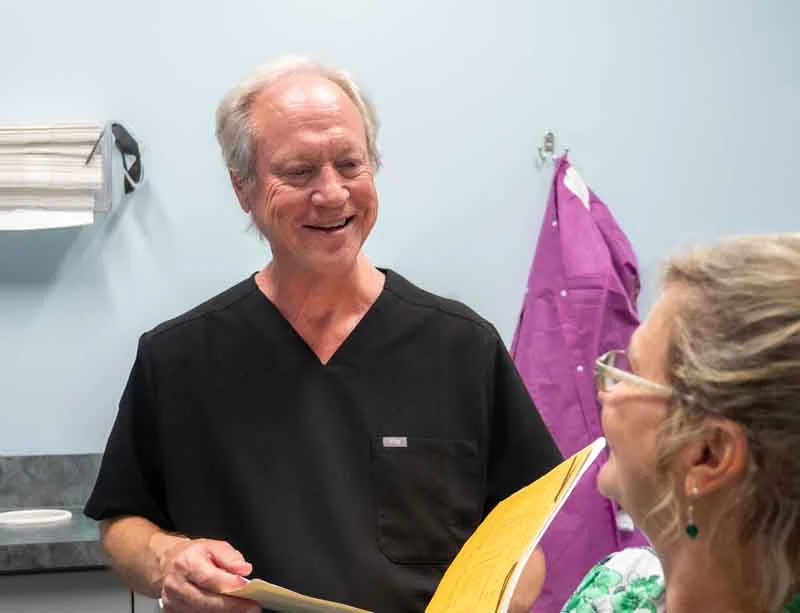 Dr. Ronald Fuhrmann discussing dental bridge options with a senior patient at Ronald Fuhrmann - Virginia Beach VA.