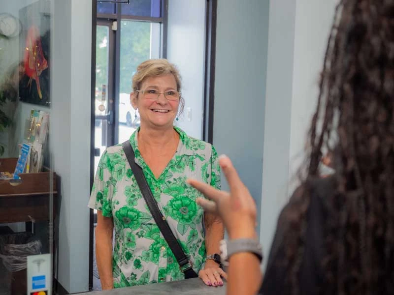 Patient checking in with the front desk to discuss restorative dental options at Ronald Fuhrmann - Virginia Beach VA.