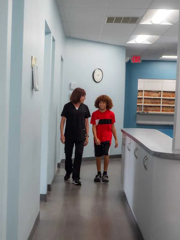 A young male patient walking into the office to discuss invisible braces at Ronald Fuhrmann DDS in Virginia Beach, VA .